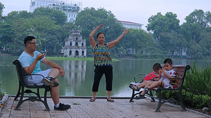 visit hanoi in early morning family at the lake